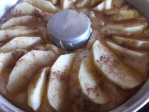 O bolo está preparado para ir ao forno coberto de gomos de maçã, mel e canela